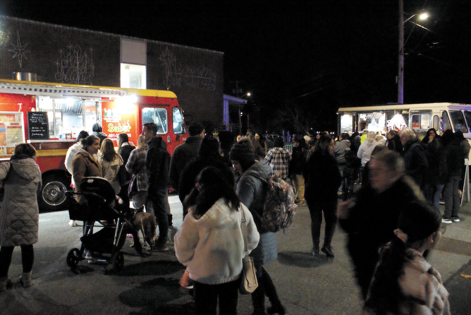 FEAST YOUR EYES: Five local food trucks were invited to cater the lighting. Visitors take a break to grab dinner. (Photo by Steve Popiel)